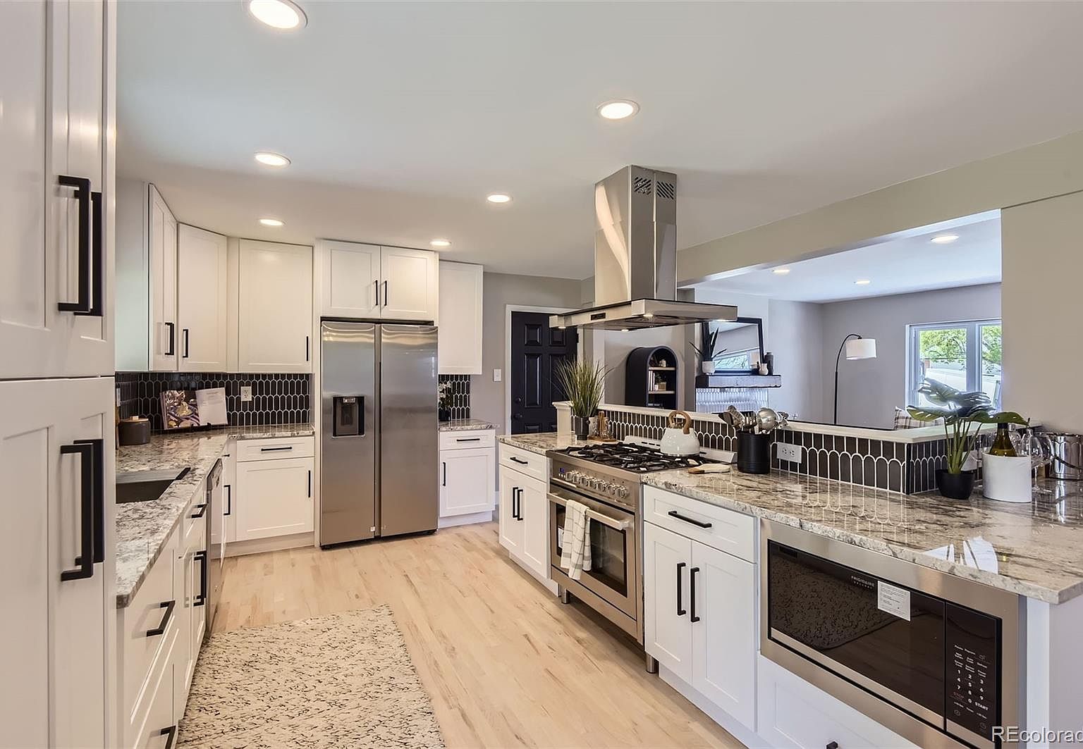 Completely renovated kitchen featuring a reconfigured floor plan, the addition of a new bar area, and a chef’s 6-burner gas stove.
